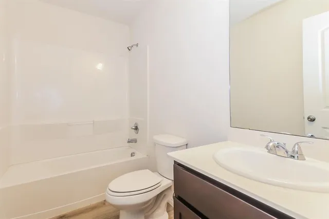 a bathroom with a granite countertop sink a toilet and a bathtub