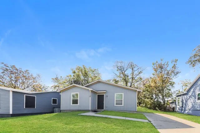 a view of a yard in front of a house with large trees