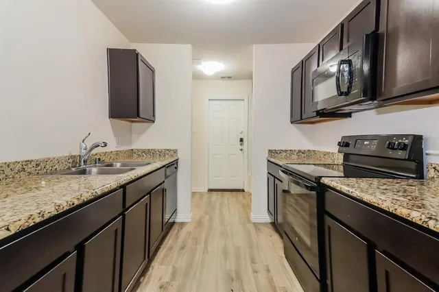 a kitchen with stainless steel appliances granite countertop a stove microwave and sink