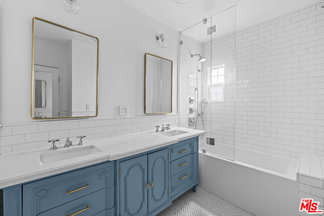 1307 South Rimpau Boulevard Los Angeles, CA 90019 - Photo 13 of 22 a bathroom with a tub double sink shower and mirror