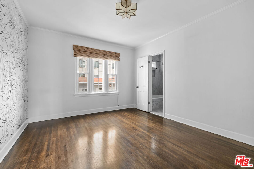 1307 South Rimpau Boulevard Los Angeles, CA 90019 - Photo 17 of 22 a view of an empty room with wooden floor and a window