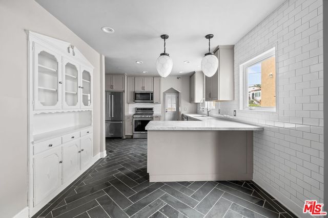 a kitchen with cabinets a sink and appliances