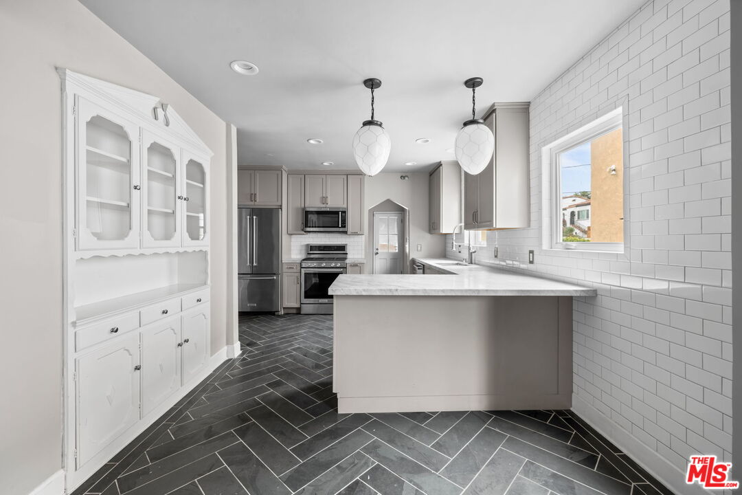1307 South Rimpau Boulevard Los Angeles, CA 90019 - Photo 8 of 22 a kitchen with cabinets a sink and appliances