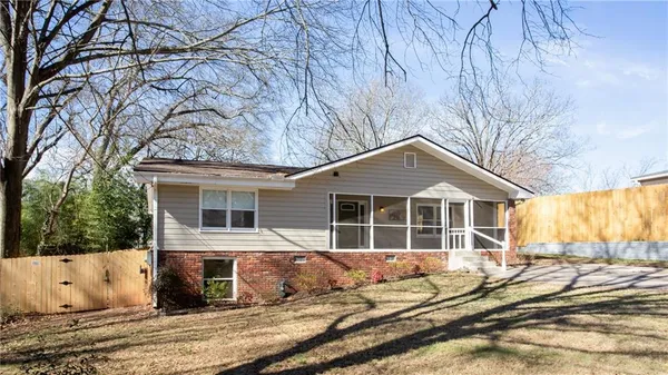 a view of a house with a yard and wooden fence