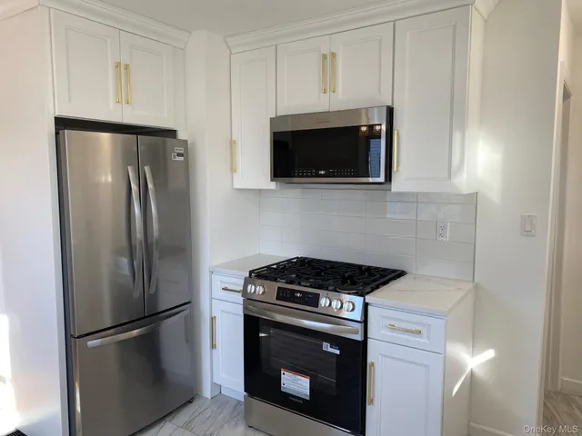 a kitchen with stainless steel appliances white cabinets and a stove