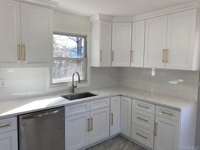 a kitchen with white cabinets and a sink