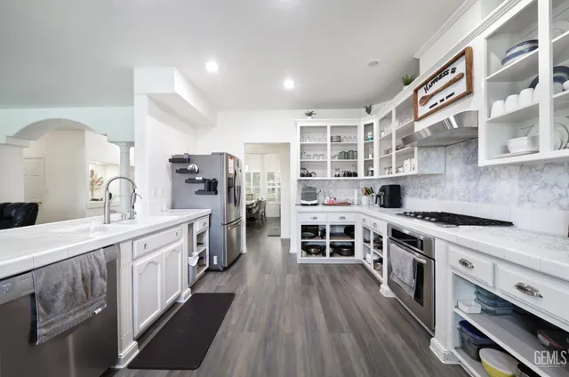 a kitchen with stainless steel appliances granite countertop a stove and cabinets