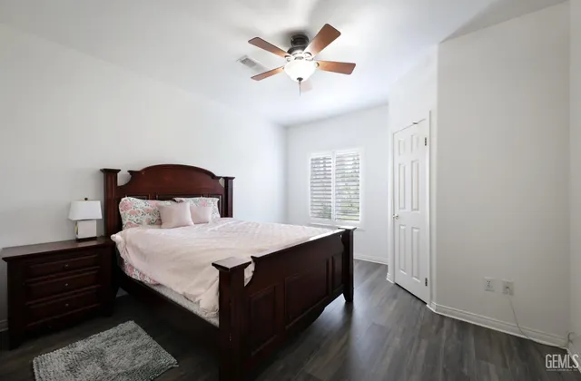 a bedroom with a bed and a ceiling fan