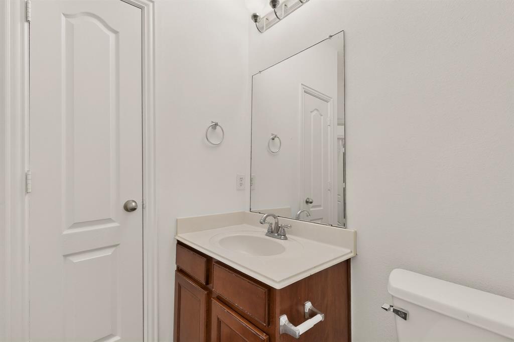 14908 Riverside Drive Little Elm, TX 75068 - Photo 18 of 40 Bathroom vanity with integrated sink, wood-finish cabinetry, and a large wall-mounted mirror