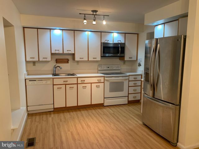 a kitchen with a refrigerator a sink and cabinets