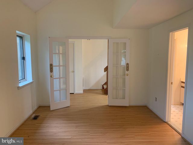 a view of empty room with wooden floor and entryway