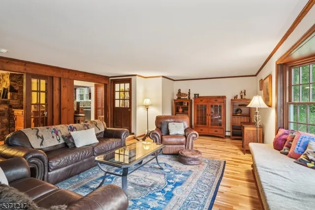 a dining room with wooden floor a chandelier a wooden table and chairs
