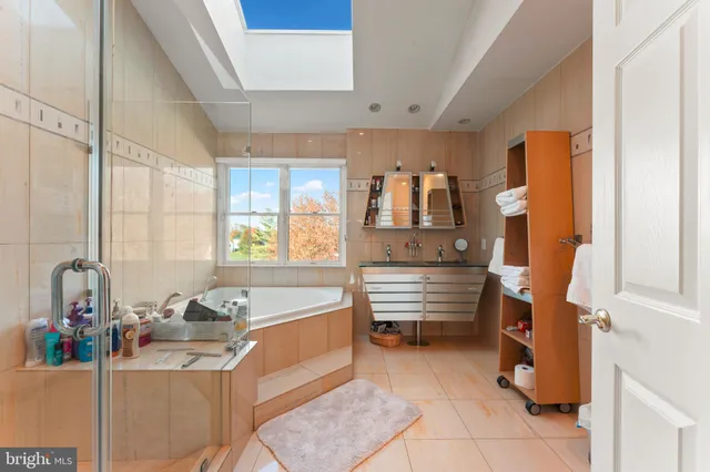 a bathroom with a tub sink and mirror