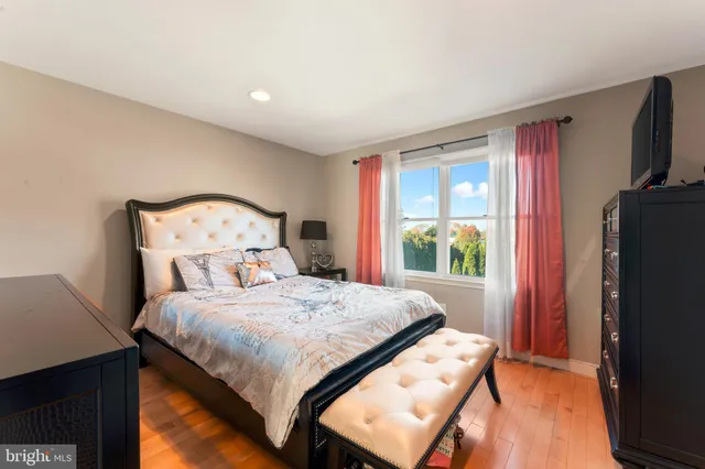 a bedroom with a bed and a flat tv screen on a dresser