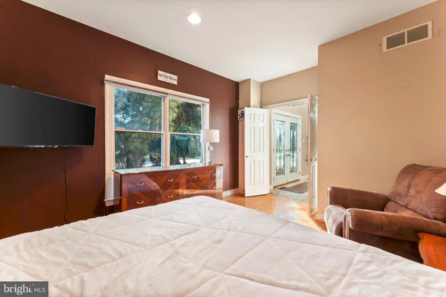 a bedroom with a bed and wooden floor