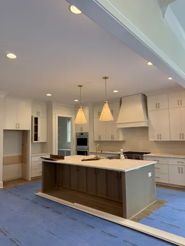 a kitchen with kitchen island granite countertop a sink cabinets and stainless steel appliances