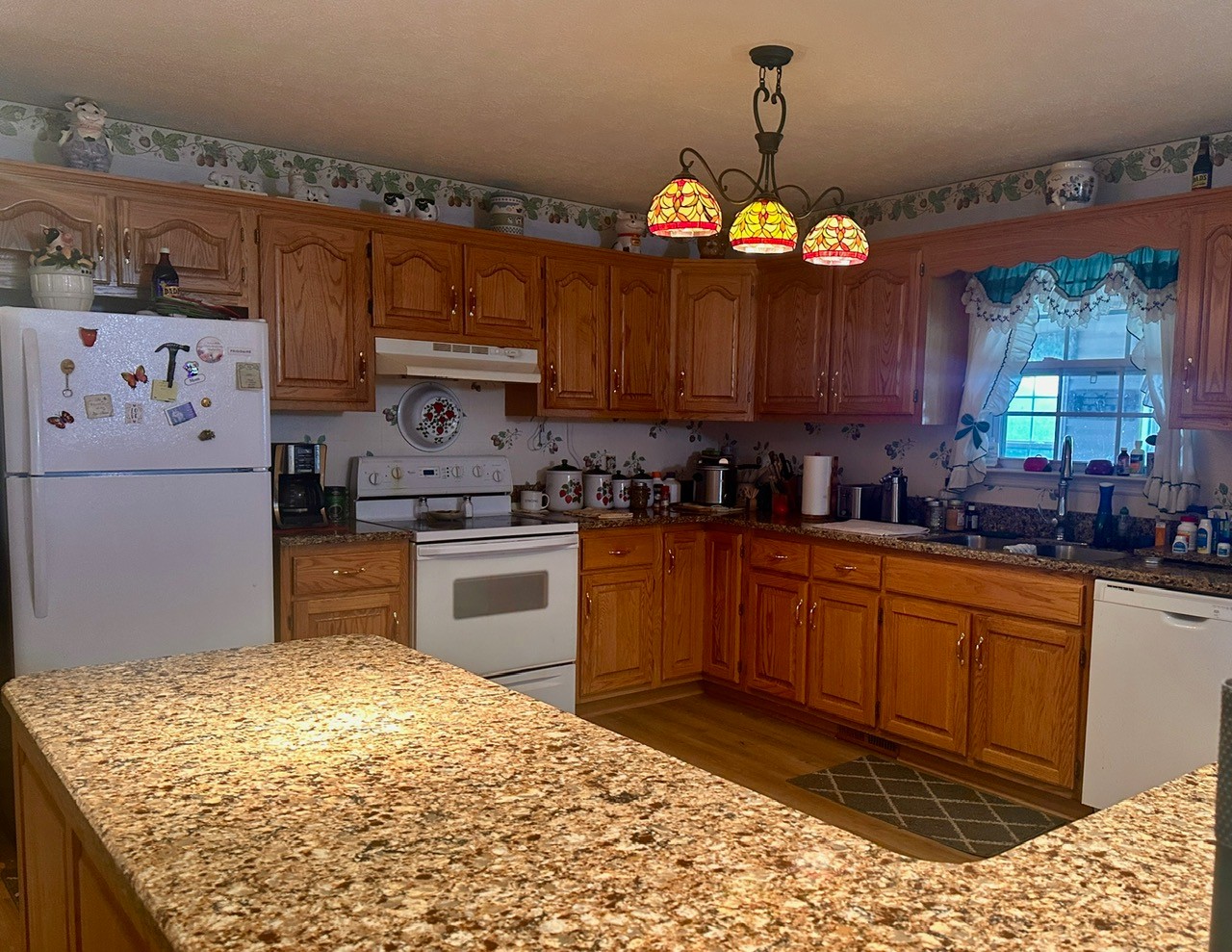 12343 Griffith Road Pikeville, TN 37367 - Photo 28 of 28 a kitchen with granite countertop wooden cabinets a sink a window and stainless steel appliances
