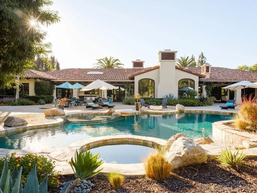 18072 Rancho La Cima Corte Rancho Santa Fe, CA 92067 - Photo 15 of 32 a front view of a house with swimming pool and outdoor seating