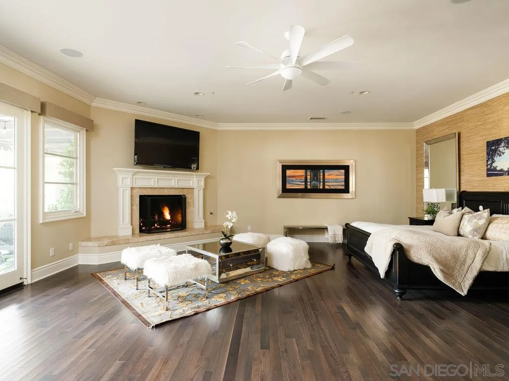 18072 Rancho La Cima Corte Rancho Santa Fe, CA 92067 - Photo 18 of 32 a living room with furniture a fireplace and a flat screen tv