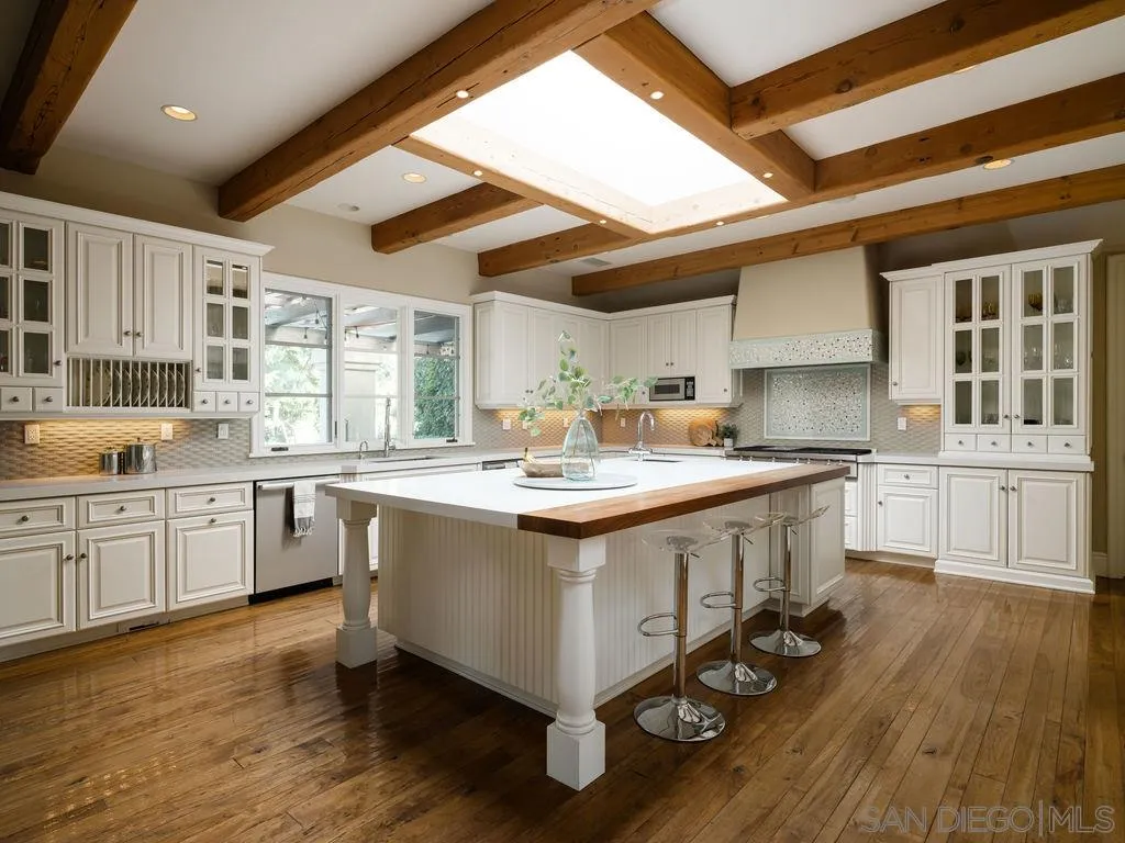 18072 Rancho La Cima Corte Rancho Santa Fe, CA 92067 - Photo 9 of 32 a kitchen with granite countertop a sink window and cabinets