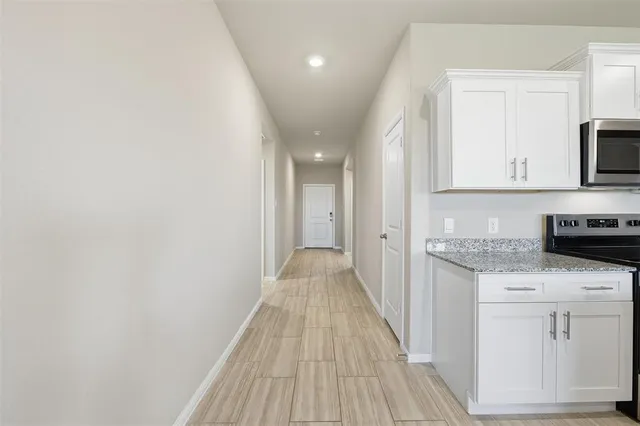 a view of a kitchen with white cabinets