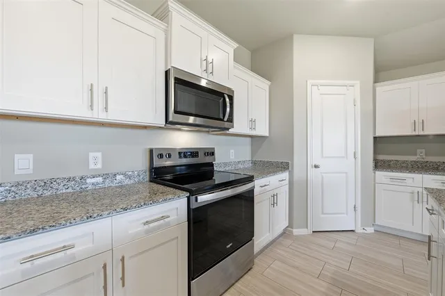 a kitchen with white cabinets and stainless steel appliances