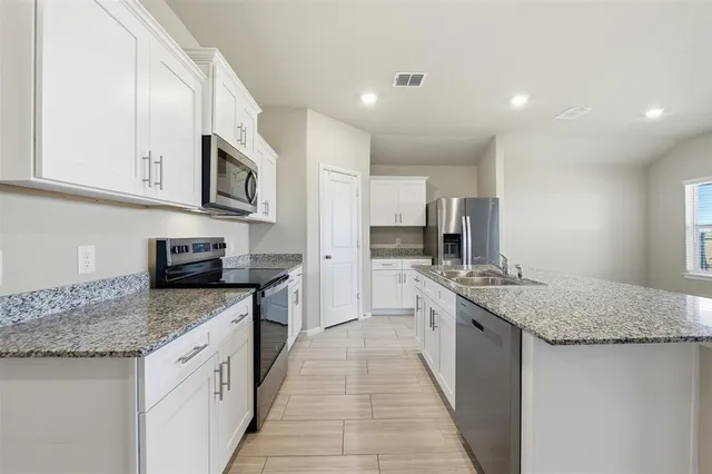 a kitchen with stainless steel appliances granite countertop a sink stove microwave and cabinets