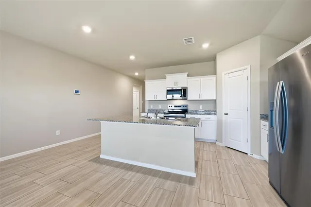 a kitchen with stainless steel appliances a refrigerator sink and white cabinets