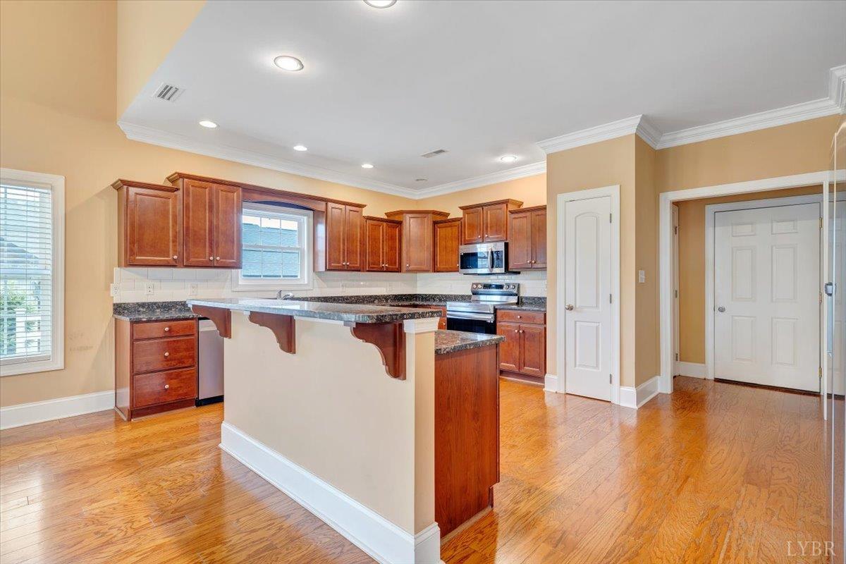 1250 Our Cove Road Huddleston, VA 24104 - Photo 14 of 70 a open kitchen with stainless steel appliances granite countertop a refrigerator a sink dishwasher a stove with wooden cabinets and floor