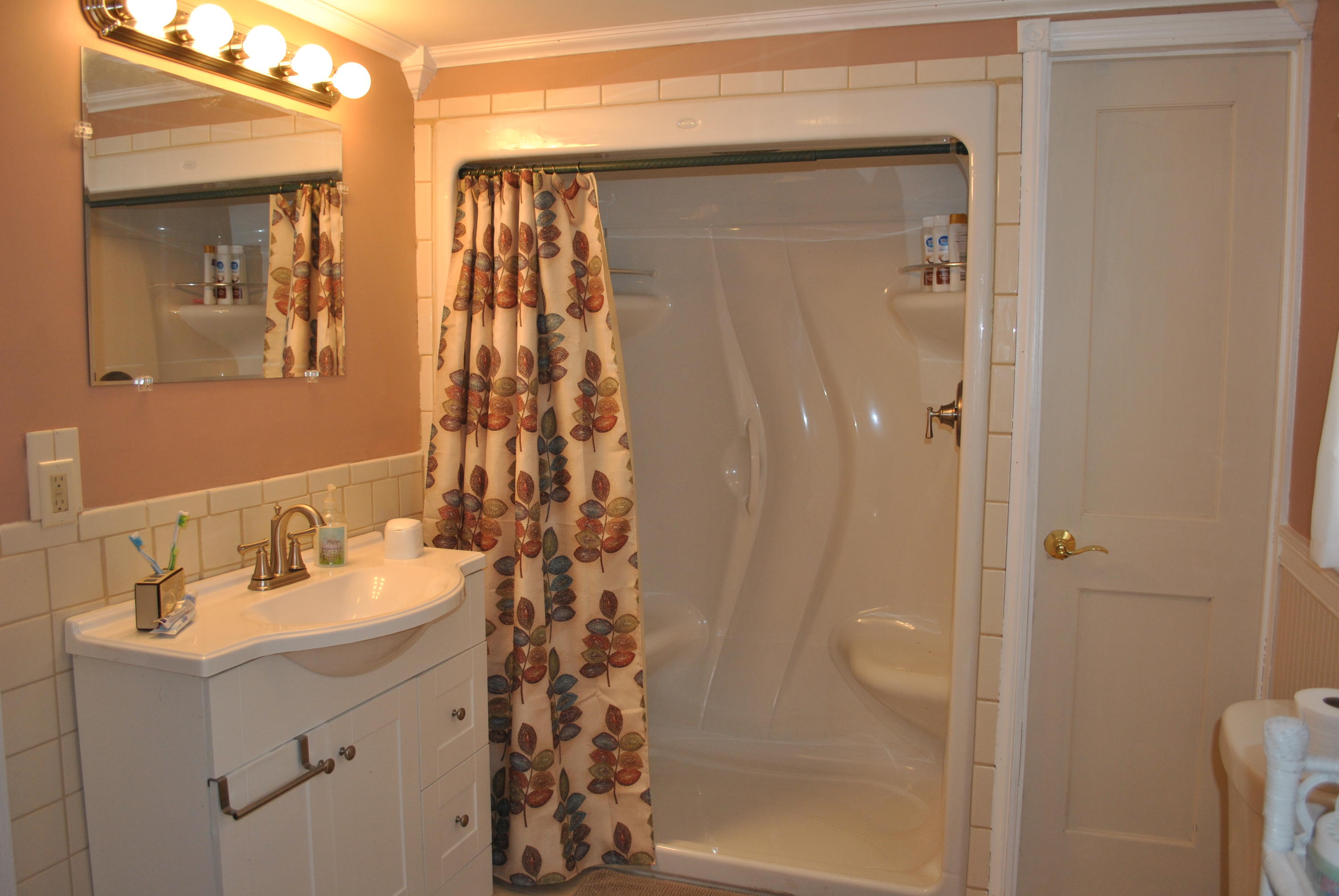 83 Lake Drive Centerville, MA 02632 - Photo 14 of 35 a bathroom with a sink a mirror a shower and vanity