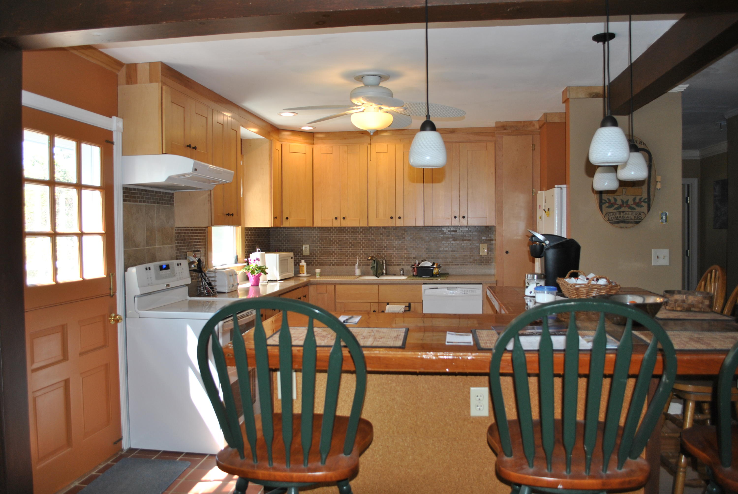83 Lake Drive Centerville, MA 02632 - Photo 3 of 35 a view of a kitchen and dining table a fireplace