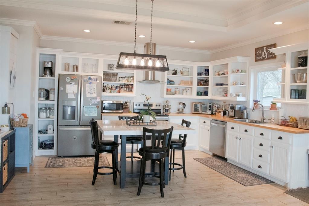 298 Redbud A Mexia, TX 76667 - Photo 14 of 40 a kitchen with stainless steel appliances kitchen island granite countertop a dining table chairs and a refrigerator