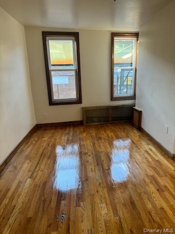 3191 Fulton Street Brooklyn, NY 11208 - Photo 5 of 8 an empty room with wooden floor and windows