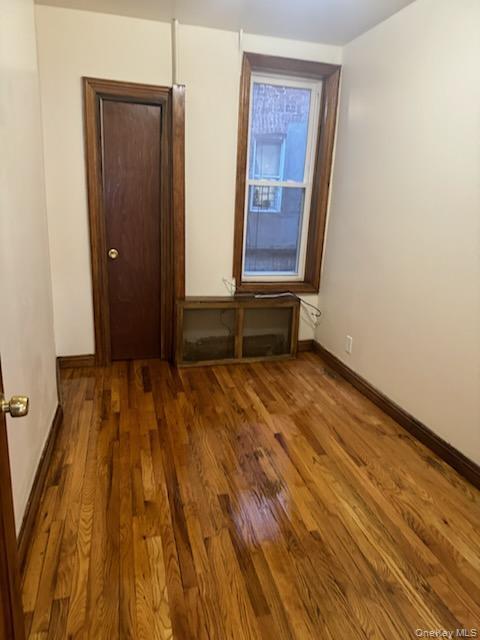 3191 Fulton Street Brooklyn, NY 11208 - Photo 6 of 8 a view of an empty room with wooden floor and a window