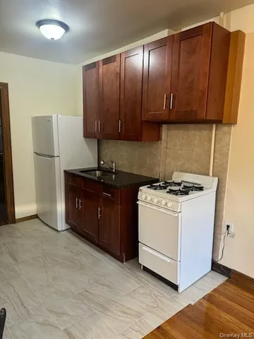 a view of a kitchen with a sink and a refrigerator