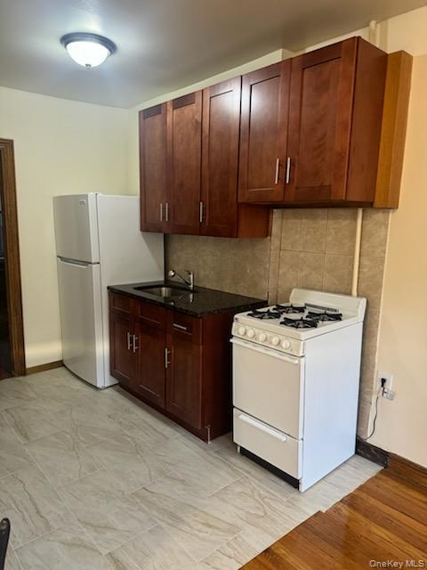 3191 Fulton Street Brooklyn, NY 11208 - Photo 7 of 8 a view of a kitchen with a sink and a refrigerator