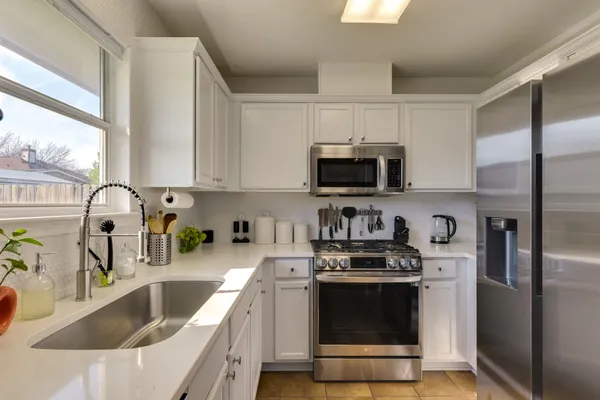 a kitchen with stainless steel appliances granite countertop a refrigerator stove and sink
