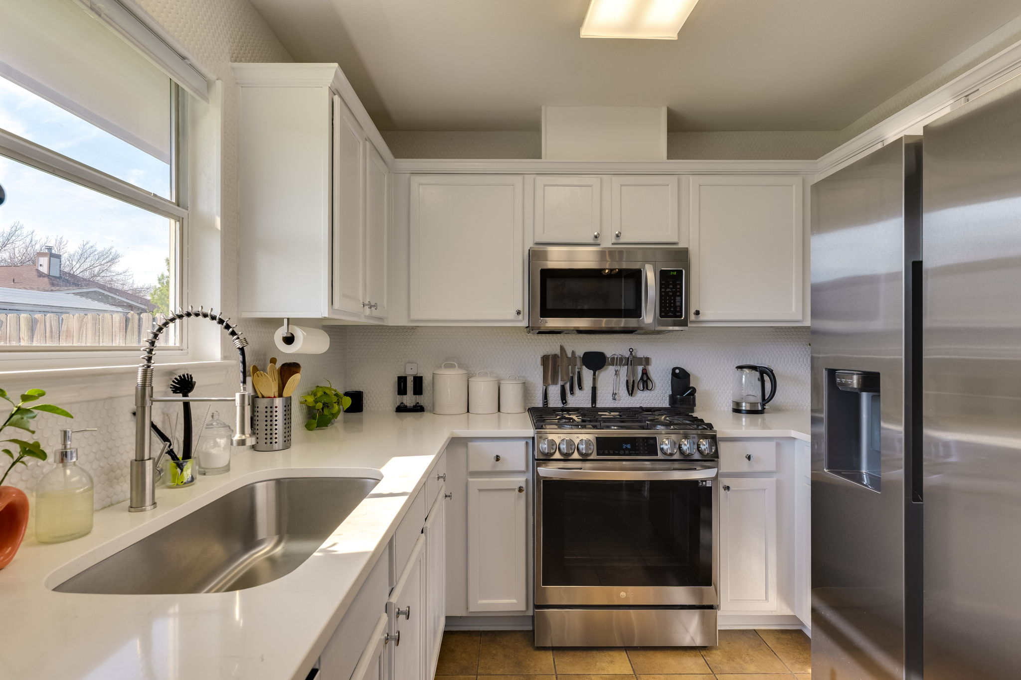 507 Clear Spring Lane Leander, TX 78641 - Photo 11 of 25 a kitchen with stainless steel appliances granite countertop a sink a stove a microwave a refrigerator a counter space and cabinets
