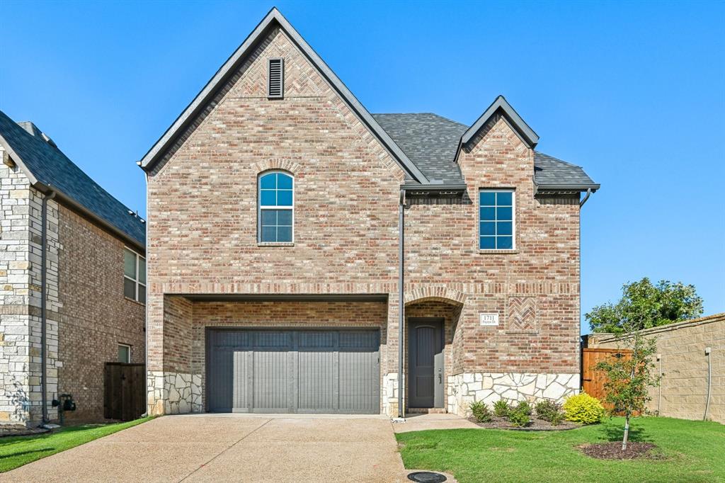 View of front of home with a garage and a front lawn