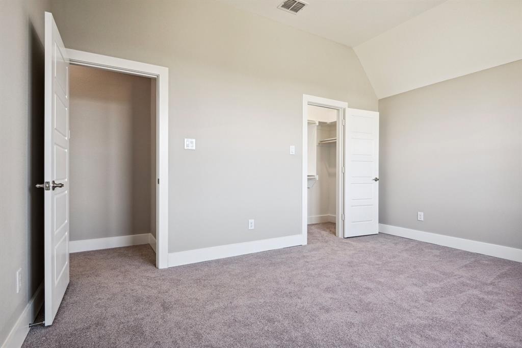 1711 Paytyn Drive Allen, TX 75013 - Photo 28 of 37 Unfurnished bedroom featuring a walk in closet, vaulted ceiling, light colored carpet, and a closet