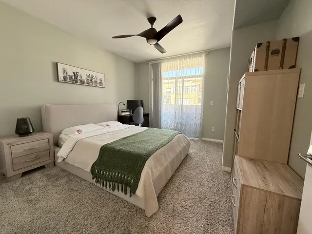 a spacious bedroom with a bed and a refrigerator