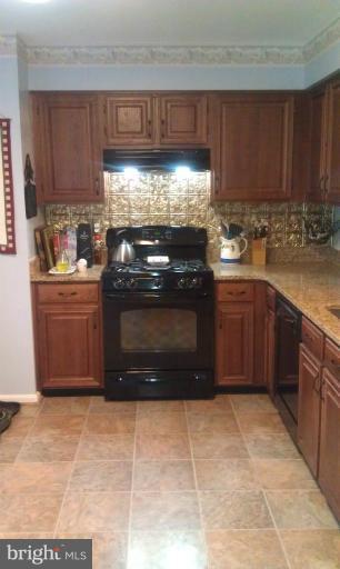 7353 St Thomas Loop Manassas, VA 20109 - Photo 11 of 20 a kitchen with stainless steel appliances granite countertop a stove a sink dishwasher and a refrigerator