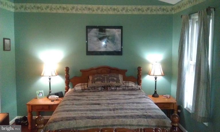 7353 St Thomas Loop Manassas, VA 20109 - Photo 16 of 20 a bedroom with a bed and a lamp