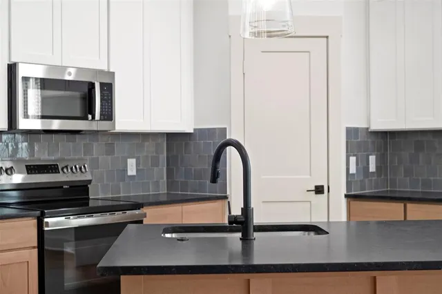 a kitchen with a sink a stove and cabinets