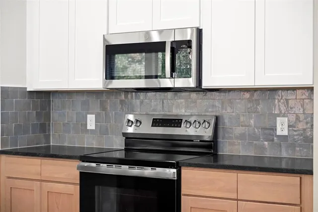 a stove top oven sitting inside of a kitchen