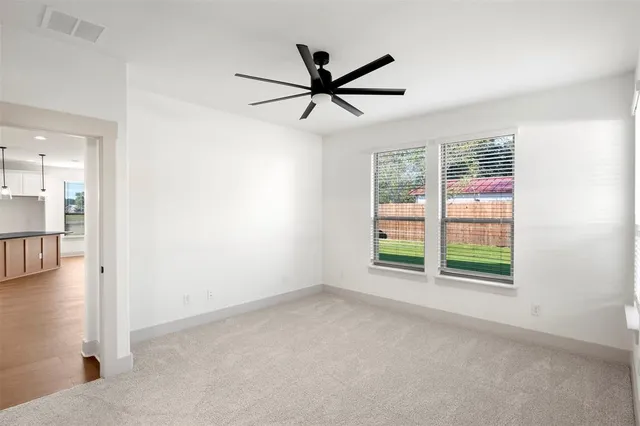 an empty room with windows and fan