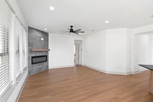 a view of a room with wooden floor and a ceiling fan