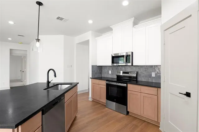 a kitchen with granite countertop a sink and a stove top oven