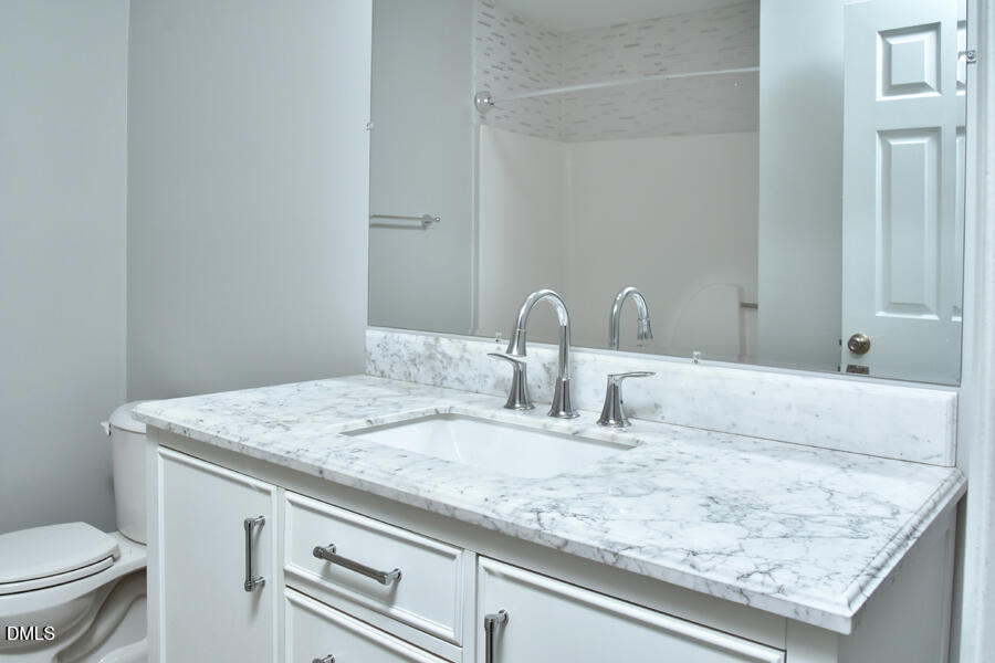 6 Justin Court Durham, NC 27705 - Photo 22 of 22 a bathroom with a granite countertop sink and a toilet