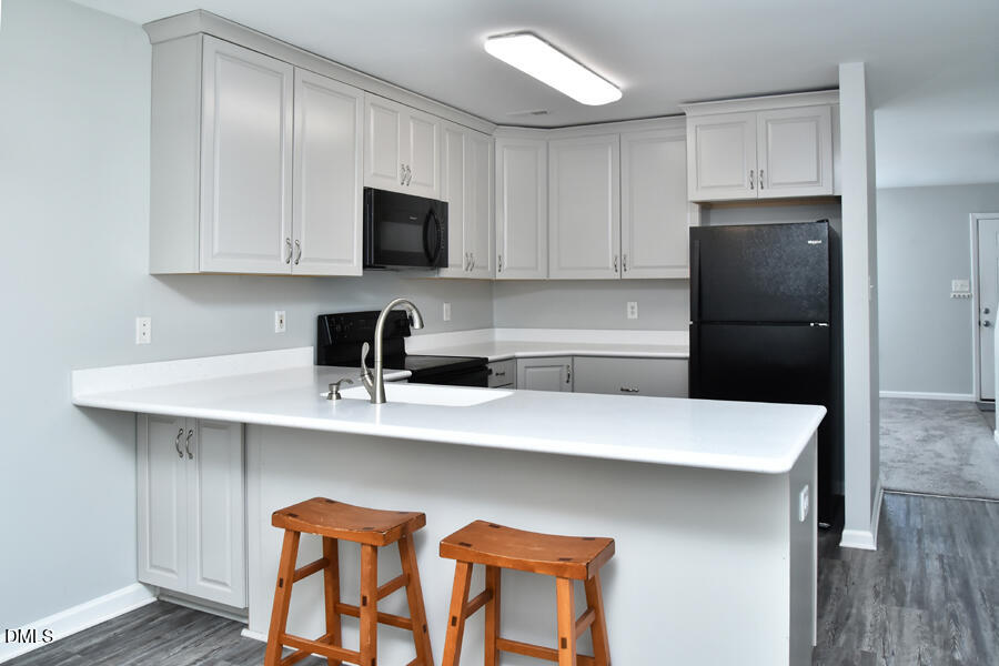 6 Justin Court Durham, NC 27705 - Photo 10 of 22 a kitchen with a sink a refrigerator and cabinets